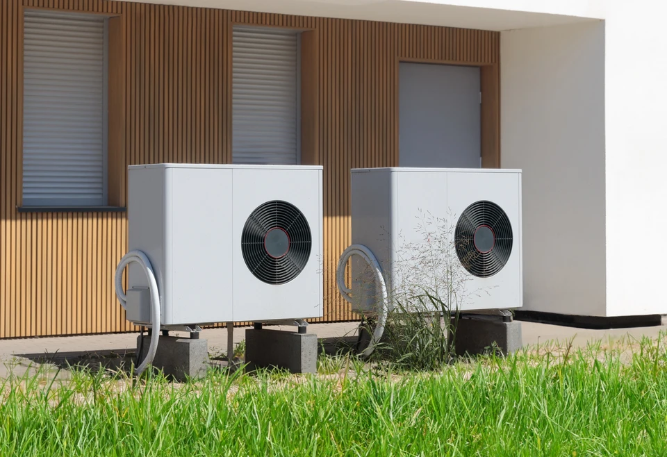 Extérieur résidentiel moderne avec pompe à chaleur air-eau installée sur terrasse béton
