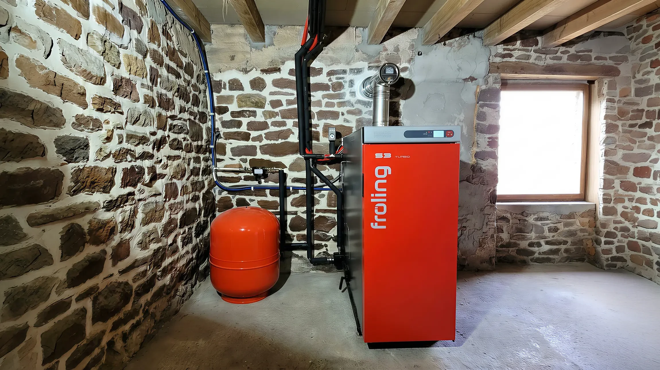 Un homme travaille sur un système de chauffage sous-pente dans un espace réduit, manipulant des connexions hydrauliques avec un outil spécialisé